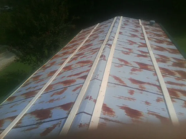 Rusted metal roof panels with new wood purlins before replacement — Storm Damage Roof Repair in Davis by Roofing Brothers